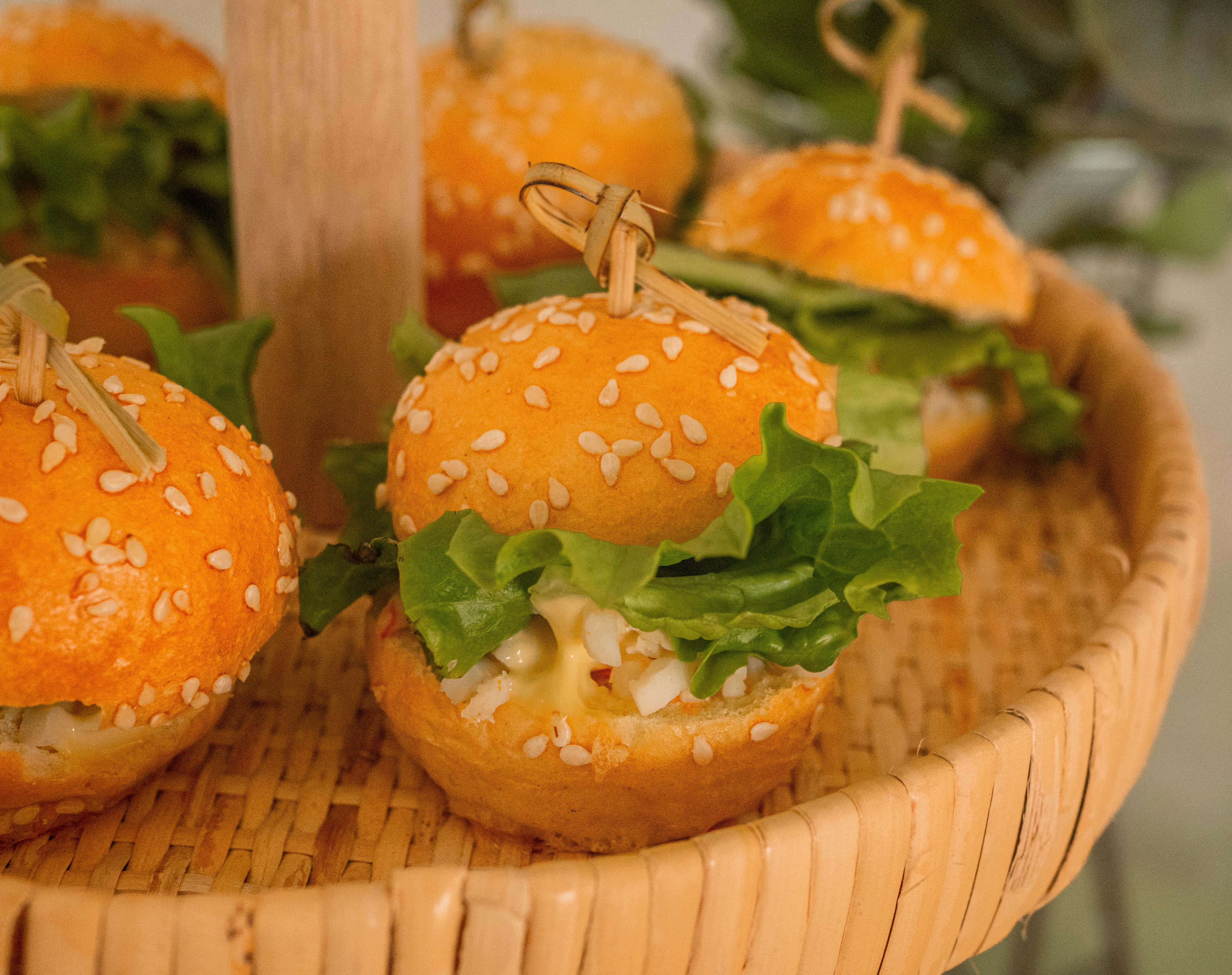 Mini-burgers gourmets dans panier en osier.