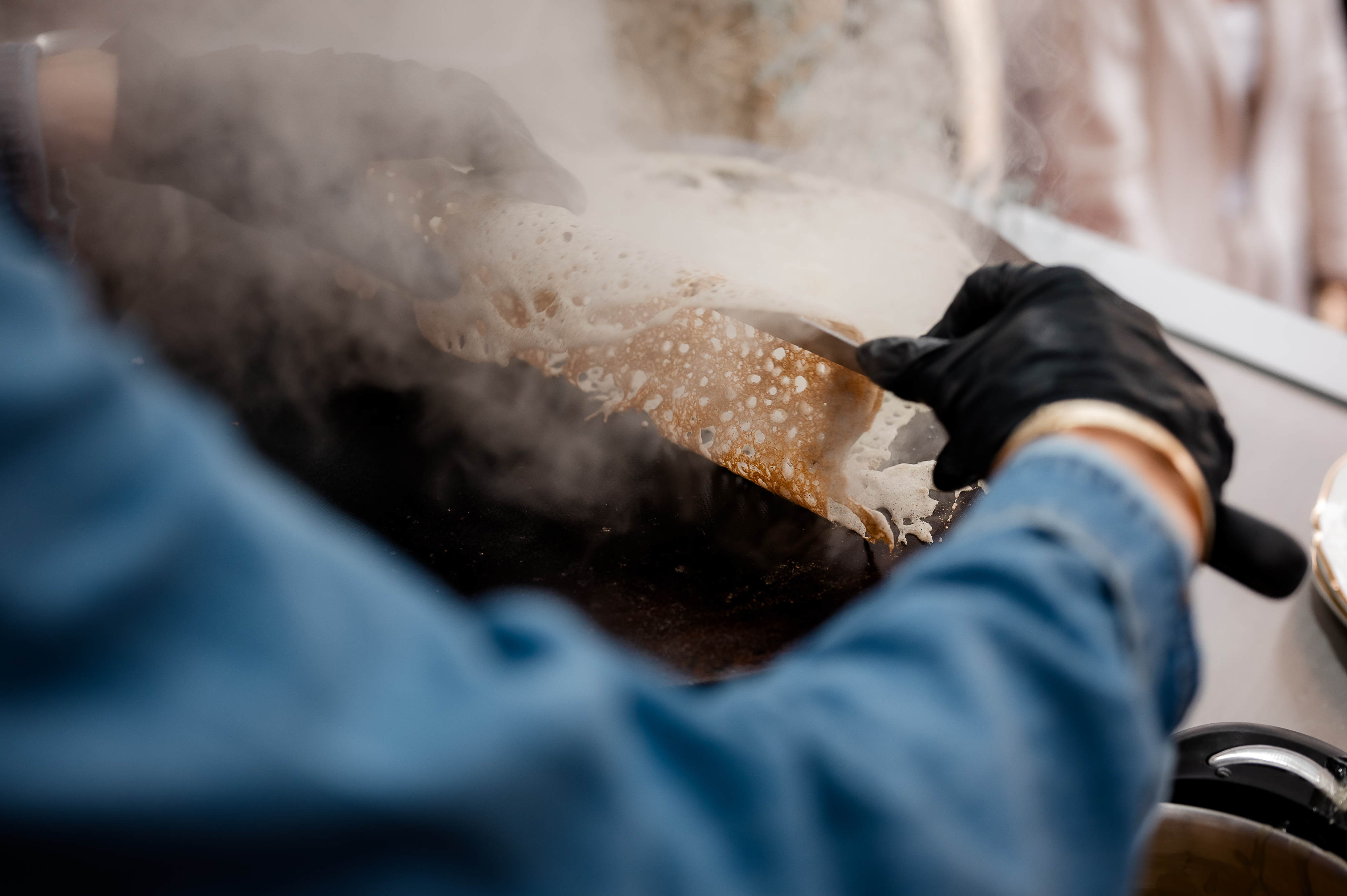 Préparation d'une crêpe sur billot chaud.